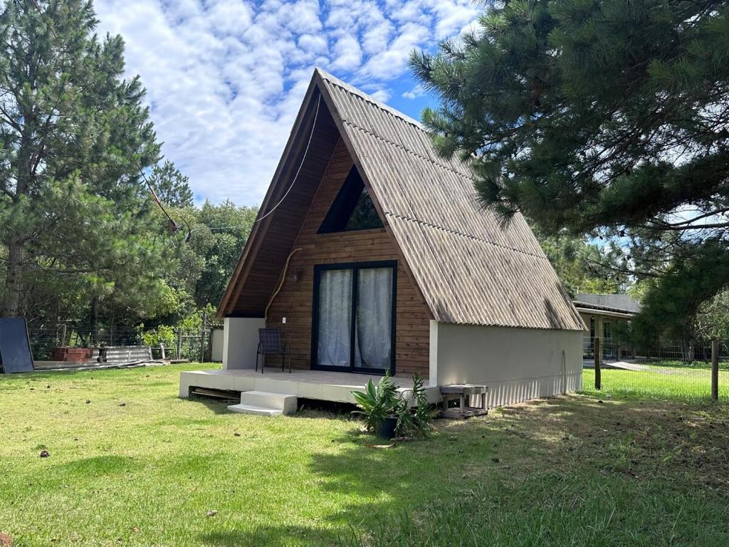 una piccola casa con tetto su un prato di Cabana Itapeva Torres a Torres