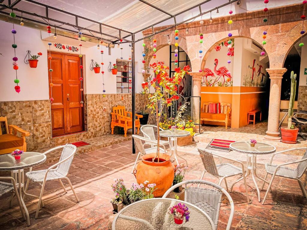 eine Außenterrasse mit Tischen, Stühlen und Blumen in der Unterkunft Apartamento Familiar con balcón y vista a la Ciudad, Centro in Cusco