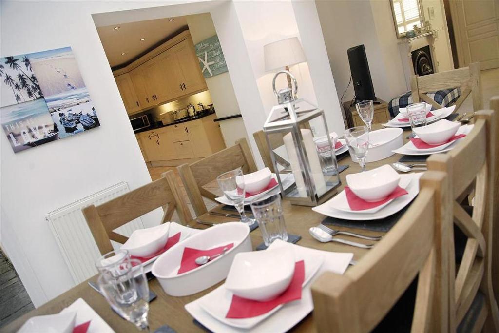 a dining room table with red and white dishes on it at 4 Bed in Gower oc-hh672 in Port-Eynon