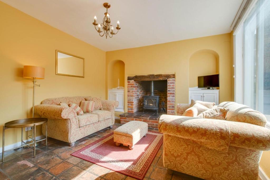 een woonkamer met twee banken en een open haard bij 2 Bed in Eye oc-4lamb in Eye