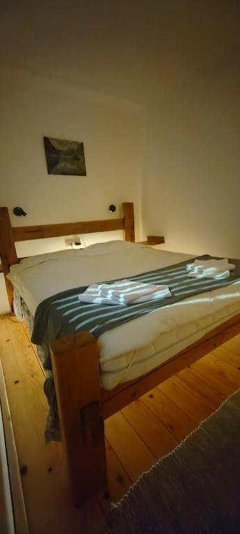 a bed in a room with a wooden floor at vila Damascena in Pirot