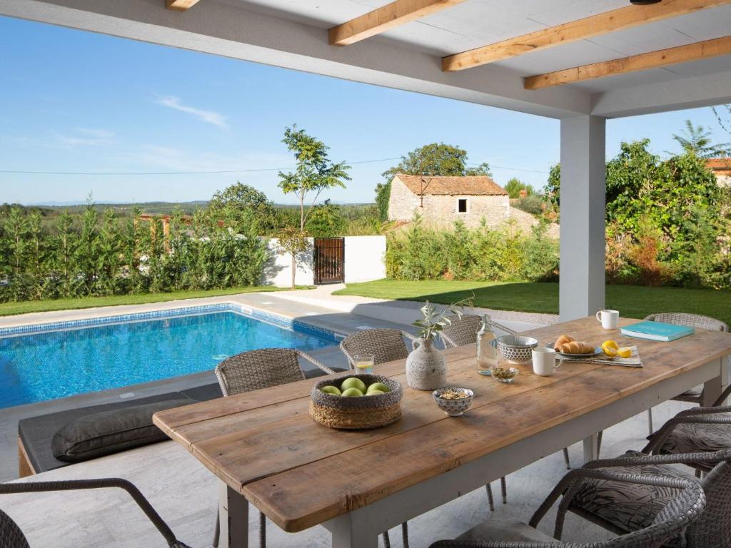 a wooden table on a patio with a swimming pool at Holiday Home mit eigenem Pool by Interhome in Čepljani