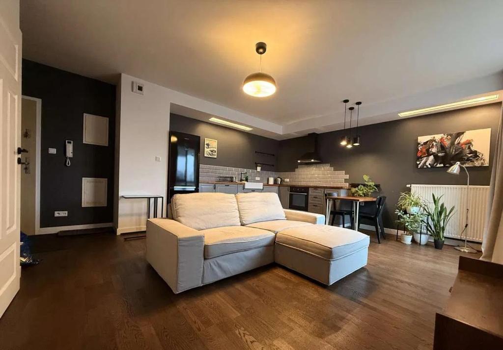 un salon avec un canapé blanc et une cuisine dans l'établissement Studio in Centro Stile Buenos Aires con Check-in Automatico H24 e Parcheggio Gratuito, à Casale Monferrato