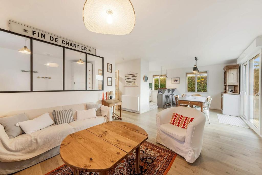 een woonkamer met een bank en een tafel bij Suzanne House 2 Bedrooms Private garden in Saint-Coulomb