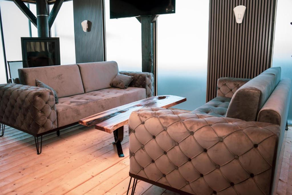 a living room with two couches and a coffee table at Apartmani Imamovic in Dubrave Gornje
