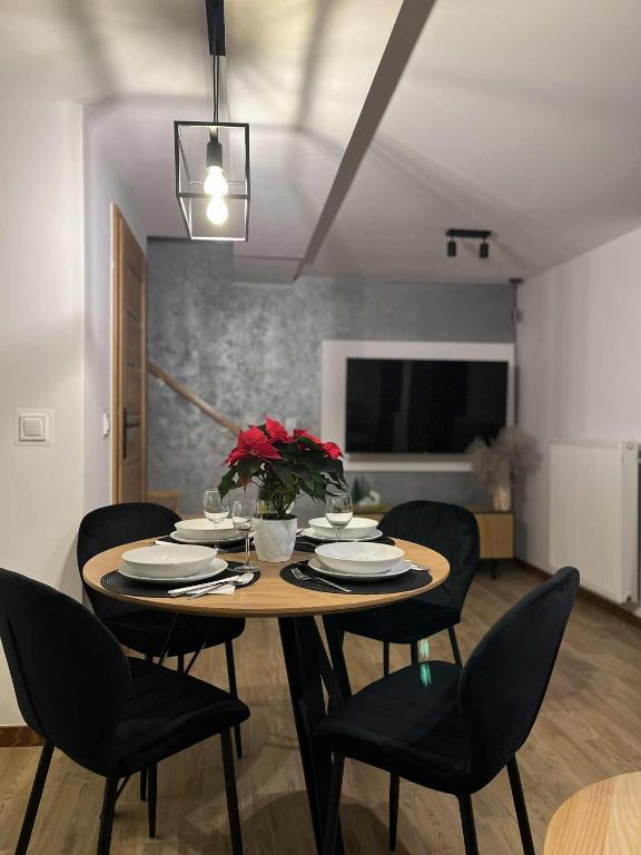 a dining room with a table with chairs and a table at Apartament Górska Przystań Kluszkowce in Kluszkowce