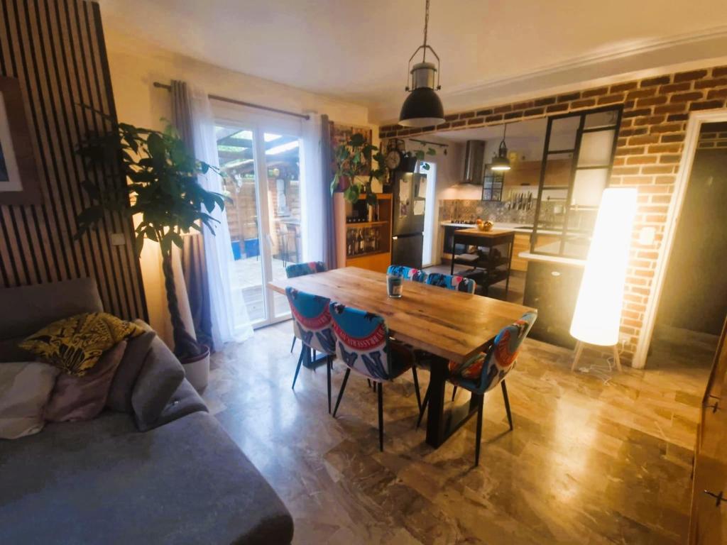 un salon avec une table et des chaises en bois dans l'établissement Maison TIKI TAHITI, à Alès
