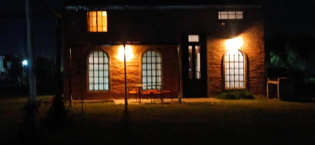 un edificio in mattoni con tre finestre di notte di El buho a Roldán