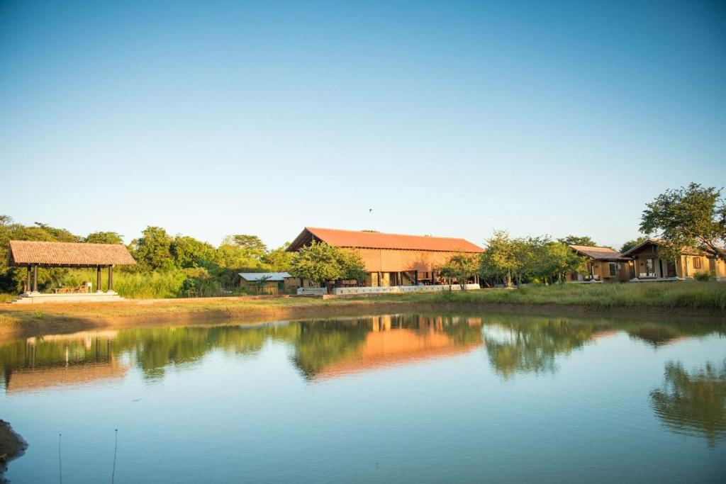 a view of a lake with houses in the background at Kumbukgaha Villa in Sigiriya