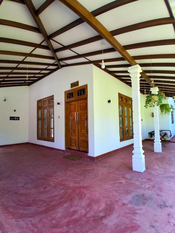 an empty room with wooden doors and purple carpet at Lagora Villa in Moraketiara