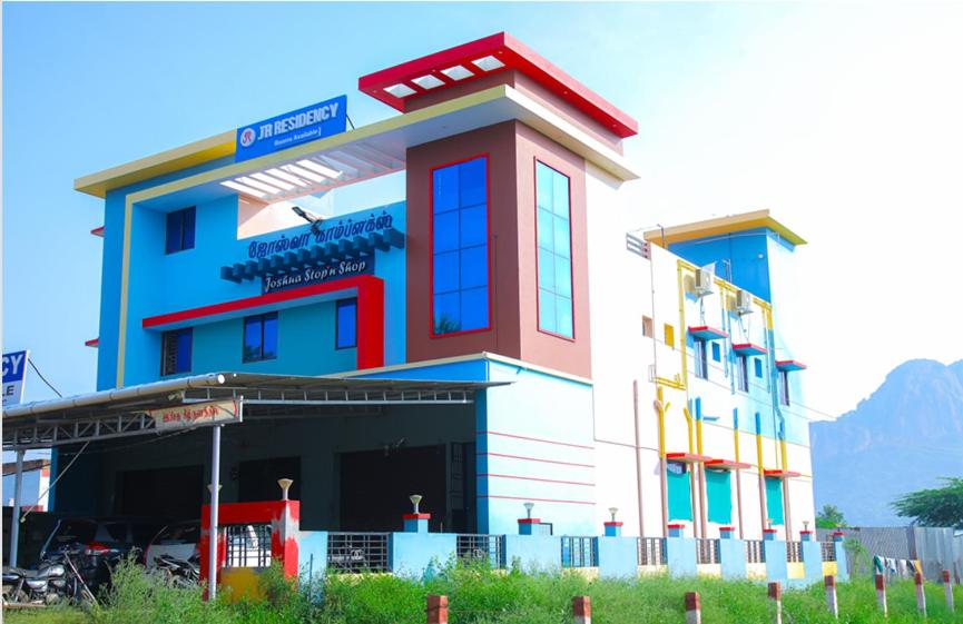 a large building with a red white and blue at JR Residency in Usilampatti