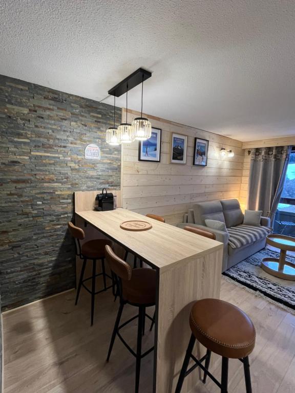 una cucina e un soggiorno con tavolo e sedie di LE CORBIER Vue pistes Studio 5 personnes entièrement rénové et labellisé Qualité Hébergement Sybelles a Villarembert