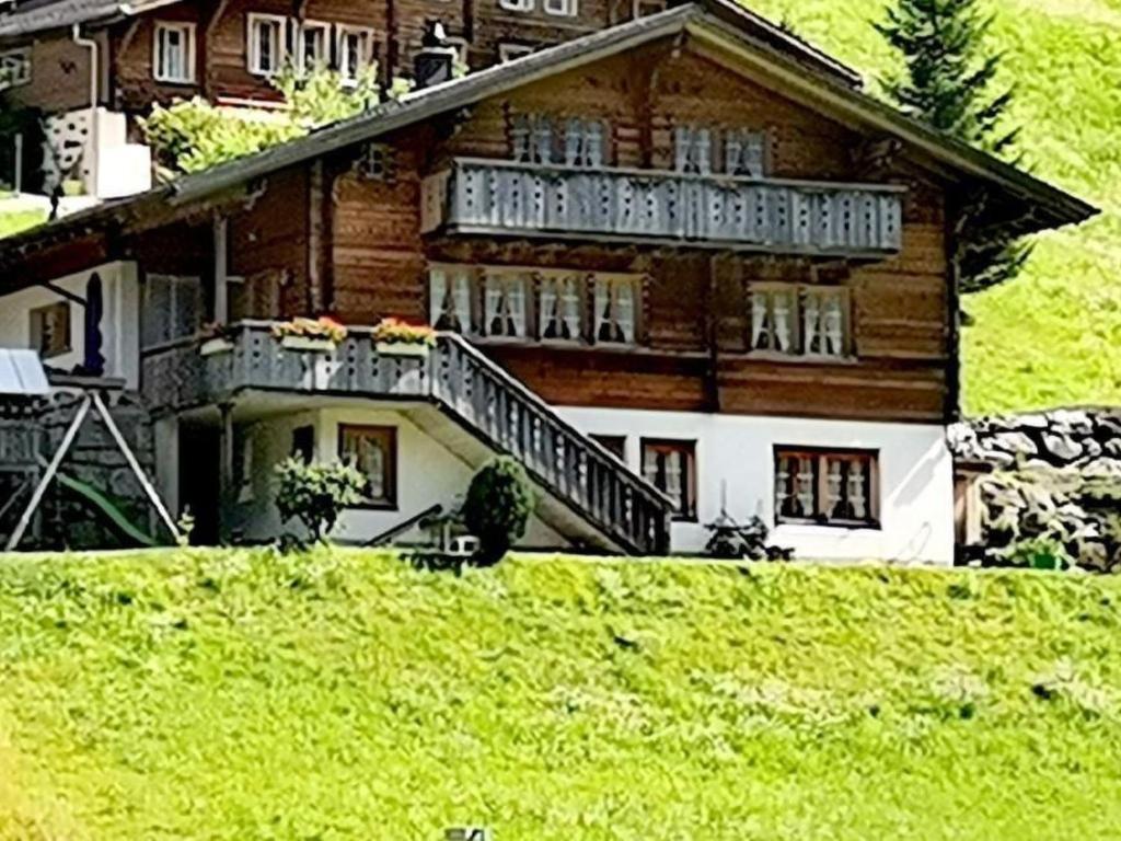 a large wooden house with a balcony on a hill at Apartment Gemütliche FeWo by Interhome in Innertkirchen