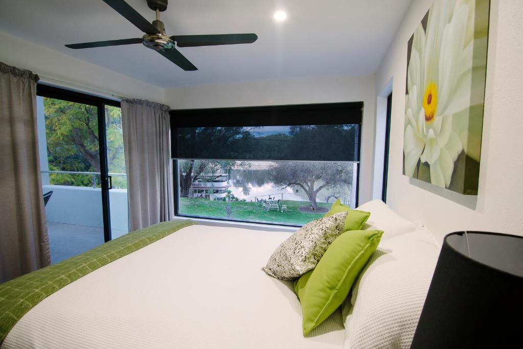 a bedroom with a bed with green pillows and a window at The Riverview BnB in Mildura