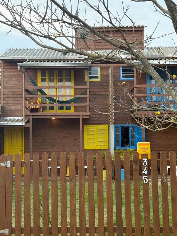 a house with yellow doors and a wooden fence at Casa no Norte da Ilha in Florianópolis