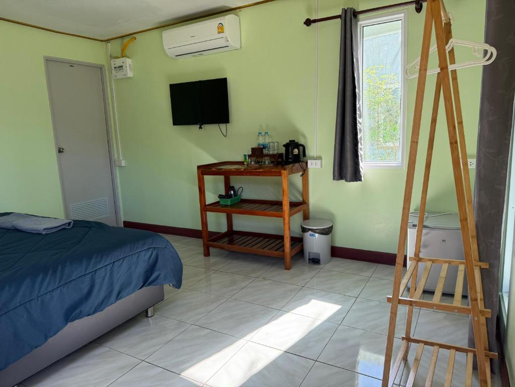 Ban Bang BaoNgopaKohKoodResort的一间卧室配有一张床、一台电视和梯子