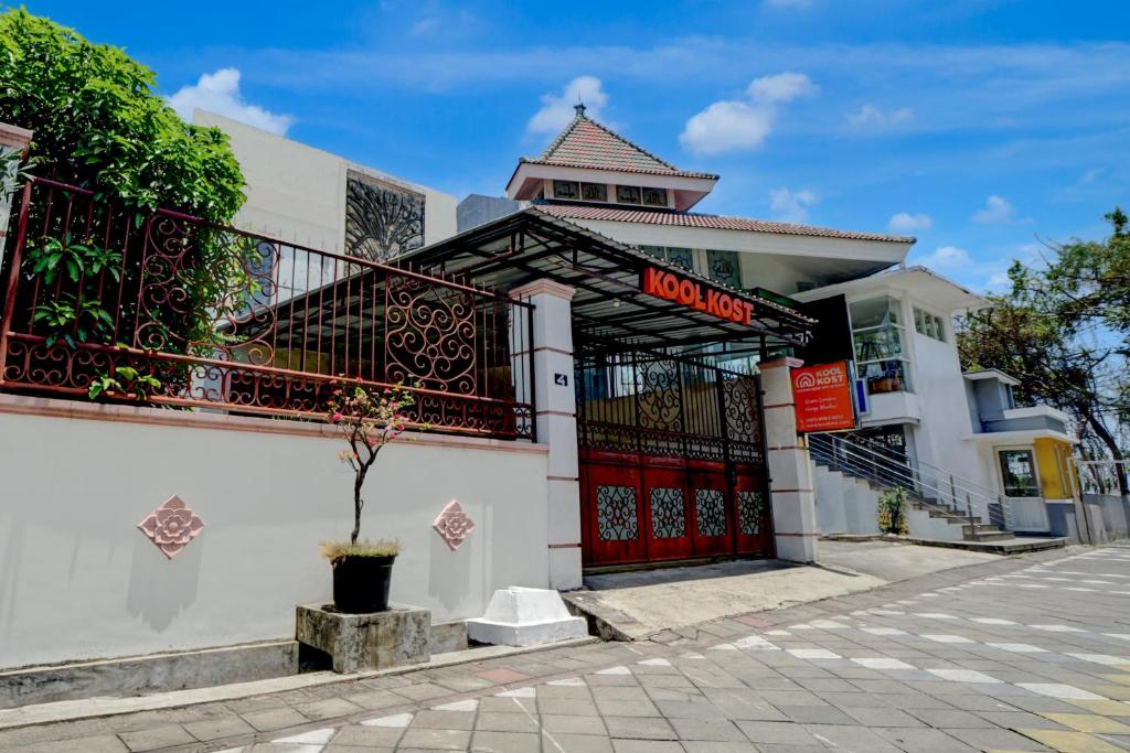 a building with a red door on a street at OYO 94899 Homestay Syariah Near UPN in Medokanayu