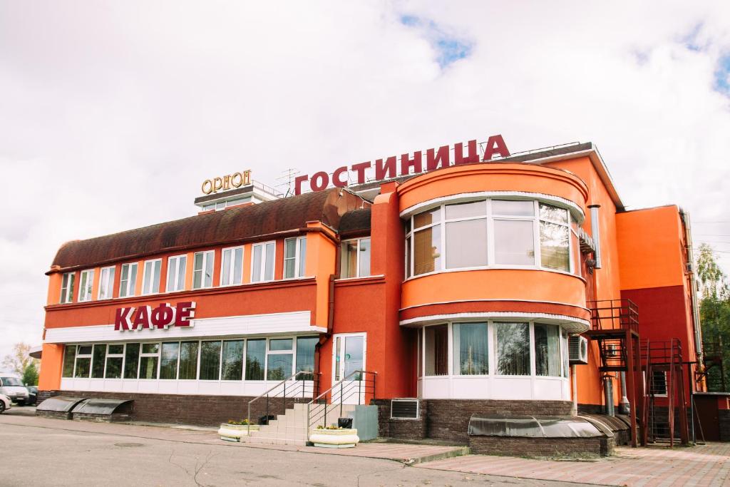 a red building with a sign on the side of it at Hotel Orion in Nizhny Novgorod