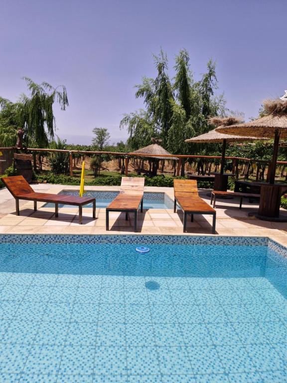 une piscine avec deux chaises et une table dans l'établissement Cabañas El Sauce, à Albardón