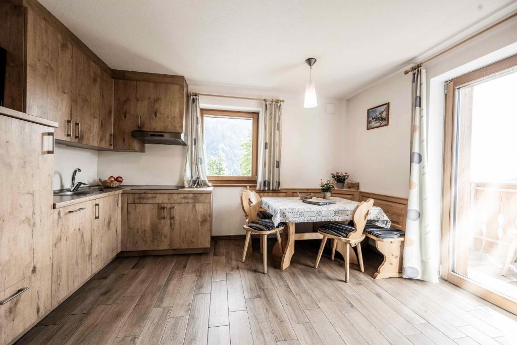 een keuken met houten kasten en een tafel en stoelen bij Oberhof Apt Lärchenwald in Vallarga