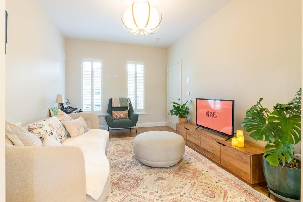 a living room with a white couch and a tv at GuestReady Cozy Dublin Hideaway in Dublin