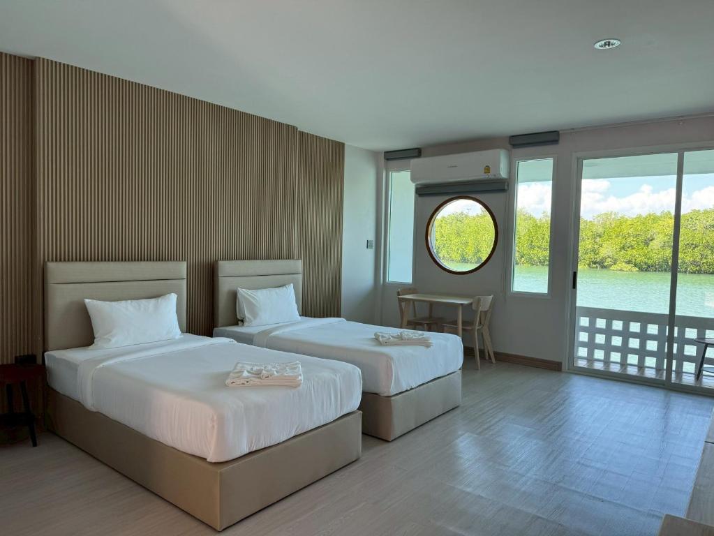 une chambre d'hôtel avec deux lits et une fenêtre dans l'établissement Madee House - มาดีเฮ้าส์, 