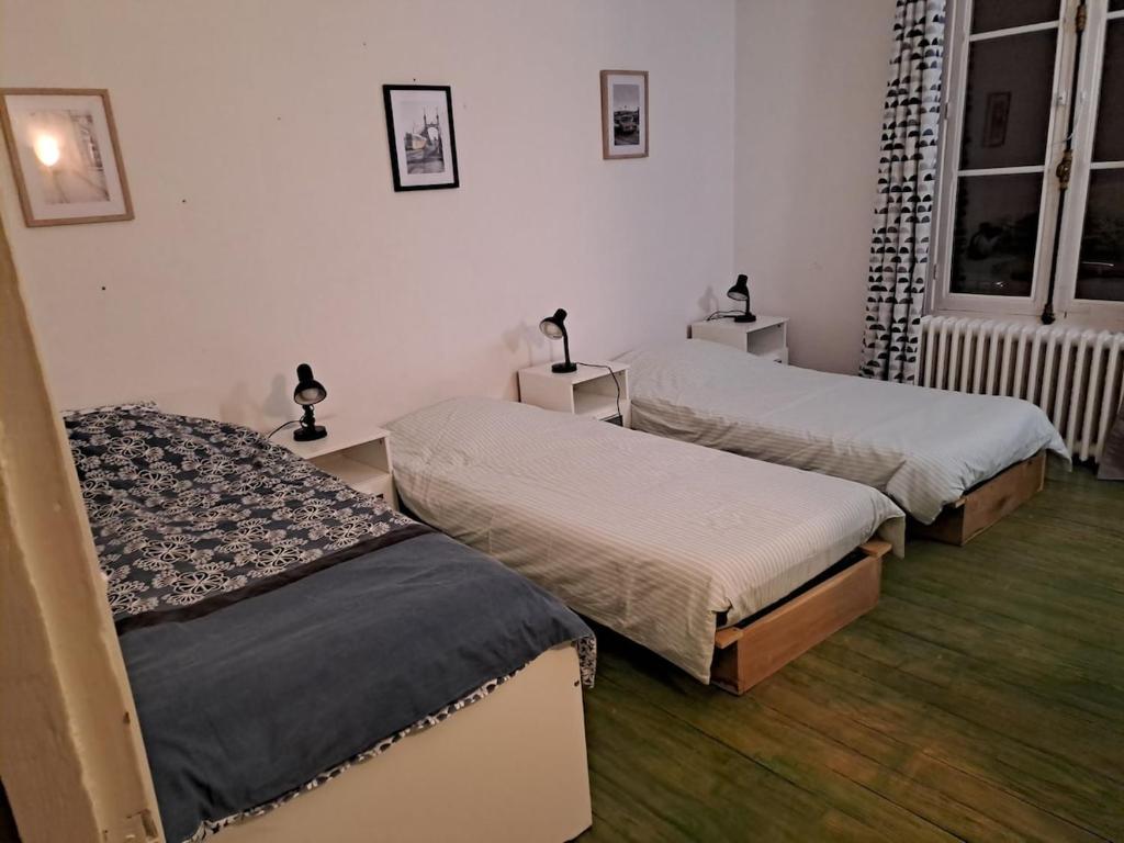 a bedroom with two beds and two windows at Grand appart 2 chambres - max 6 pers in Vrigne-aux-Bois