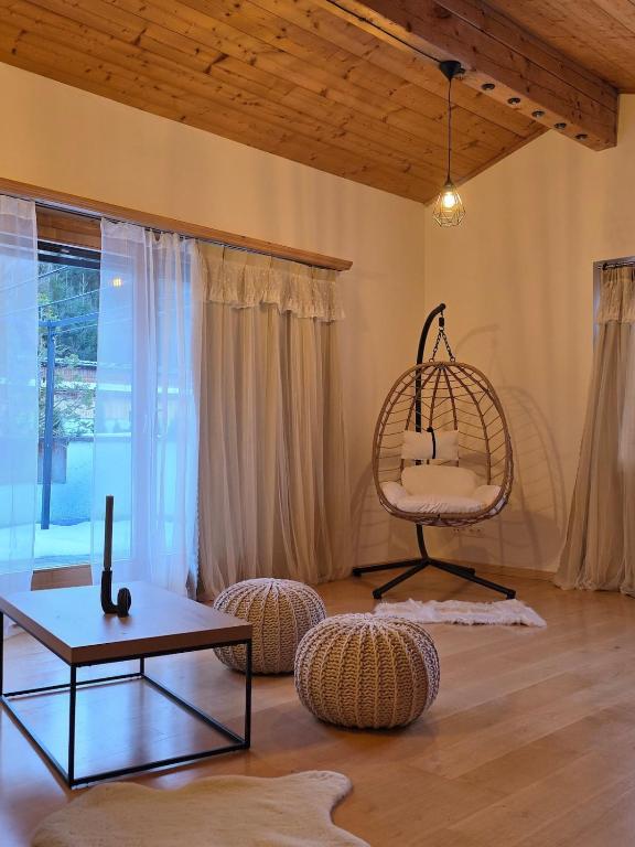 a living room with a table and a chair at Glory Igls Lodge in Innsbruck