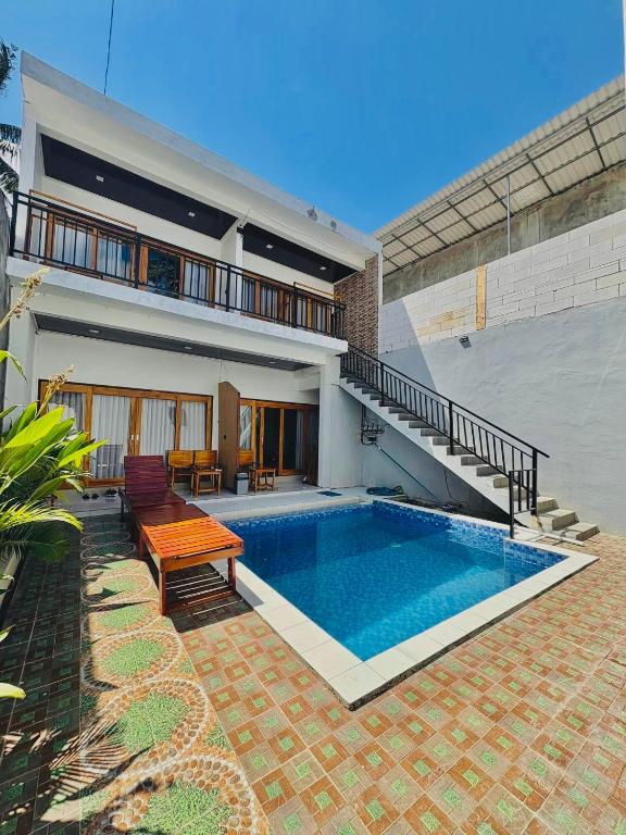 a house with a swimming pool in the backyard at NeNa Eat & Sleep Kuta in Kuta Lombok