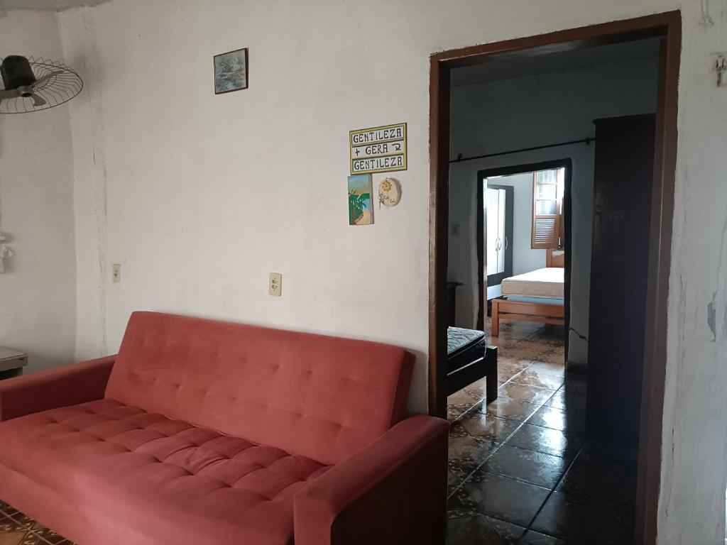 ein rotes Sofa in einem Zimmer mit einem Schlafzimmer in der Unterkunft Casa no Centro da cidade! in Goiás