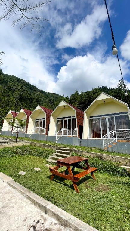 een picknicktafel in het gras voor gebouwen bij Diiza Glamping Tawangmangu Private Pool No BBQ in Tawangmangu