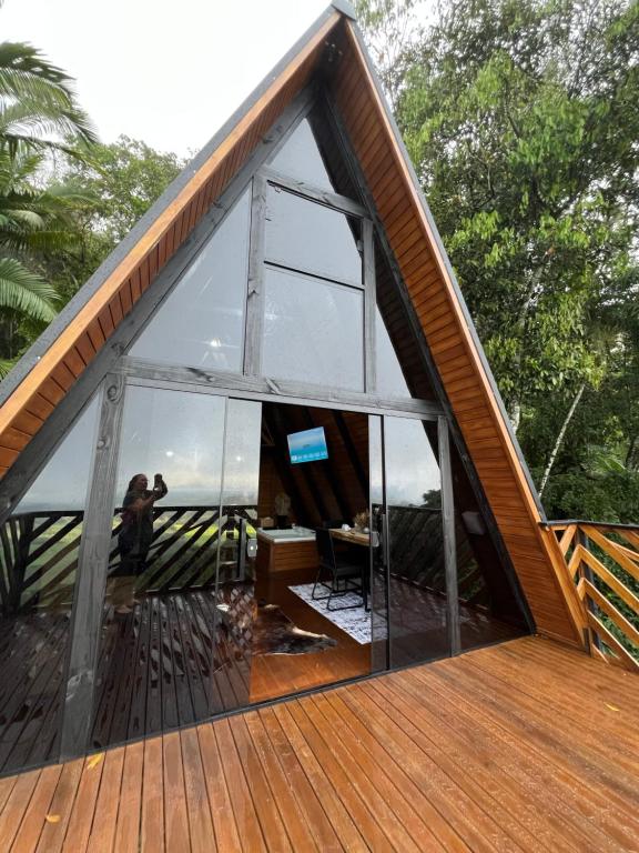 a house with a large window on the deck at Chalé das pedras in Massaranduba