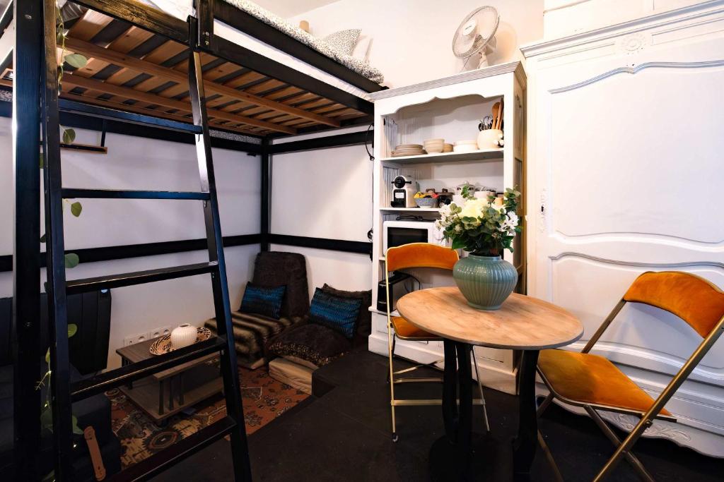 Zimmer mit einem Tisch und einem Etagenbett in der Unterkunft Studio design Pigalle Montmartre in Paris