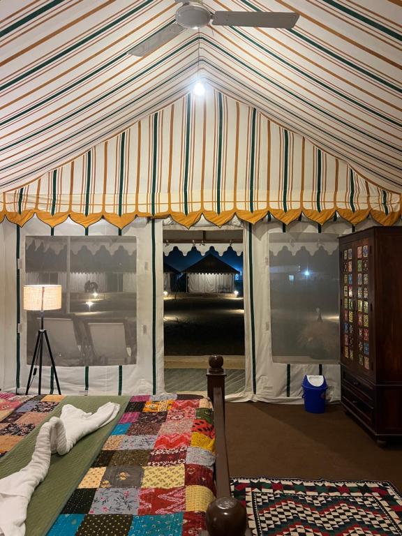 a bedroom with a tent with a bed and a table at Venture Desert Camp Jaisalmer in Jaisalmer