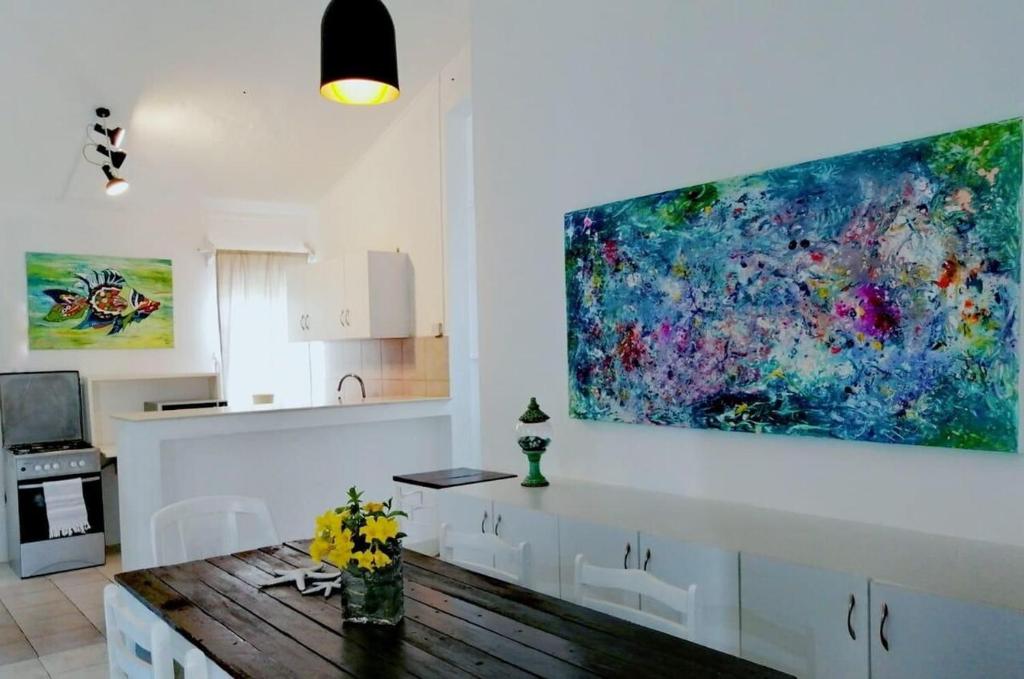 een keuken met een groot schilderij aan de muur bij La Oursha Apartment in Pointe aux Biches