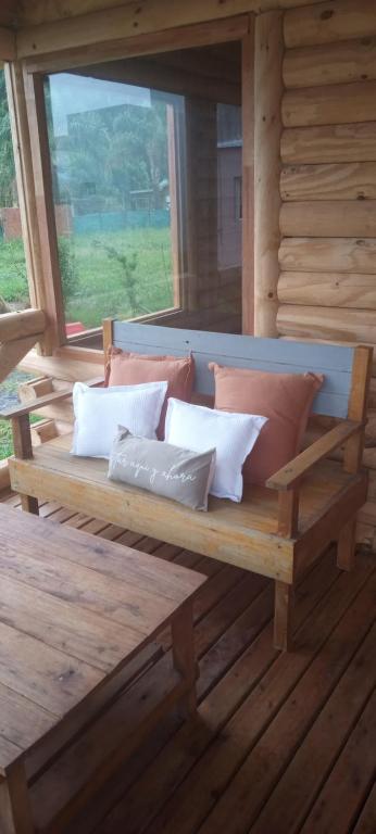 Verde Oliva في فيديراسيون: مقعد خشبي على شرفة كوخ خشبي