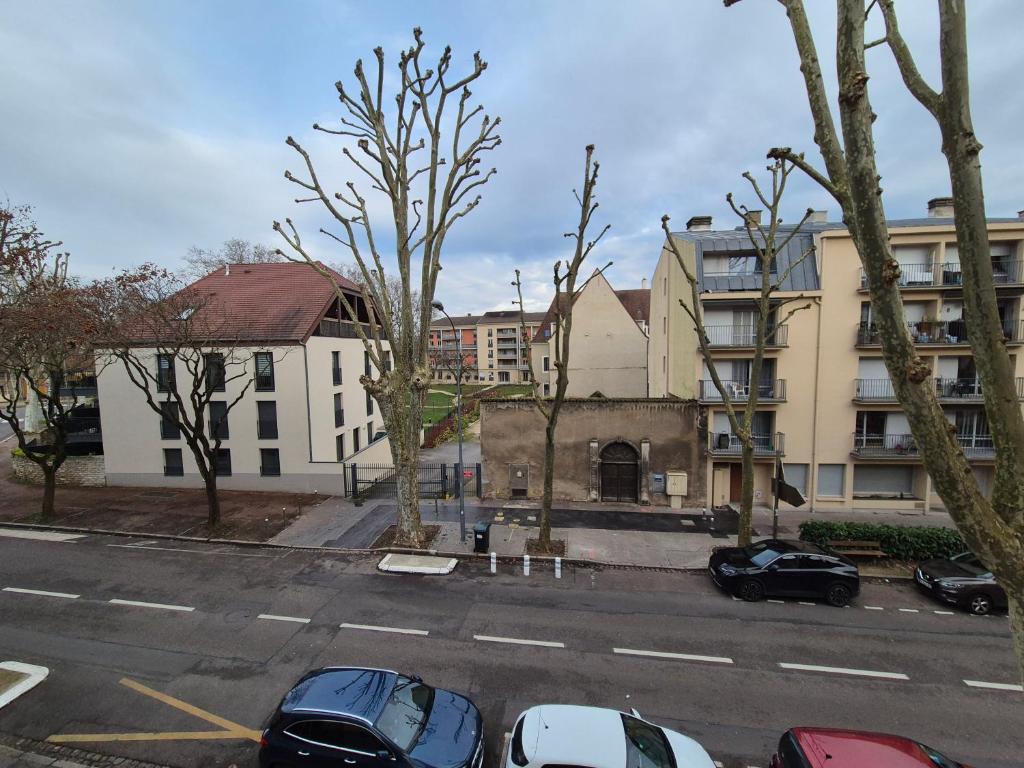 een straat met auto's geparkeerd voor een gebouw bij Le rempart in Chalon-sur-Saône