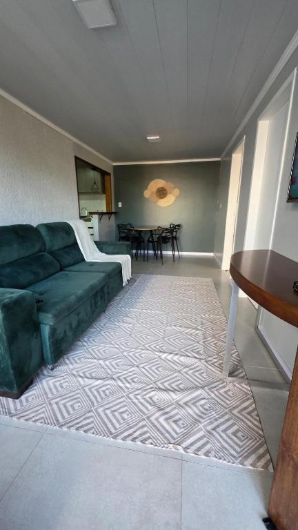 a living room with a green couch and a table at Casa completa, lindamente decorada, nova com 2 quartos in São Gabriel
