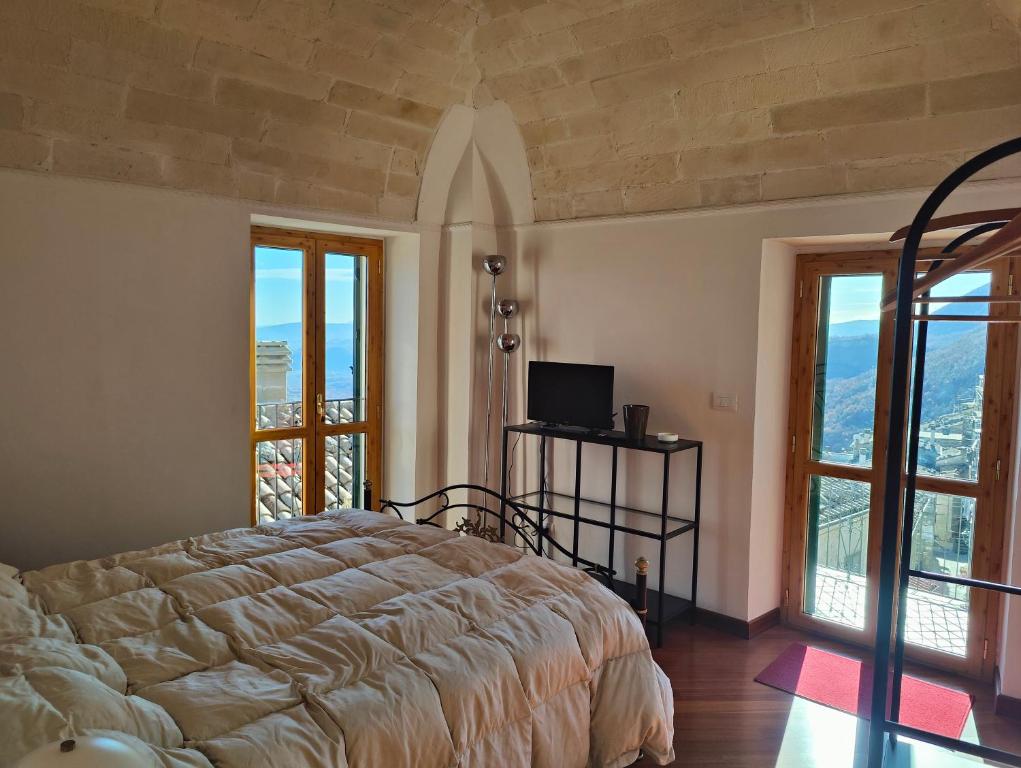 una camera da letto con un letto e due finestre di Casa Viola della Maiella a Pennapiedimonte