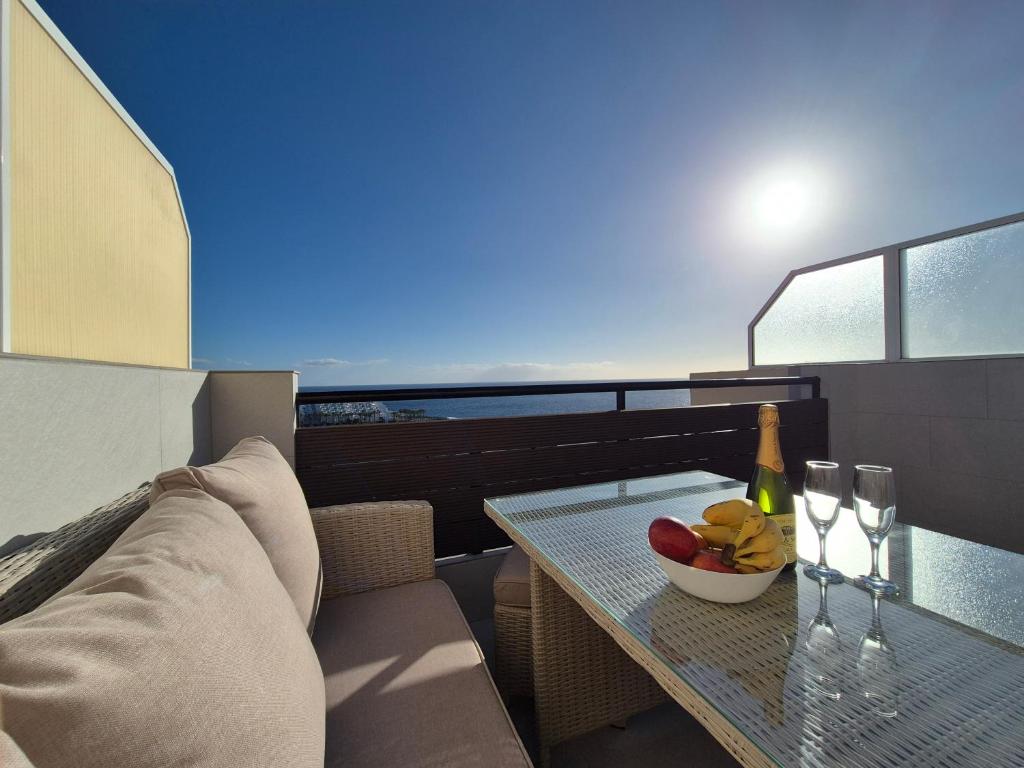 a table with a bottle of wine and a bowl of fruit at Paraiso View Duplex Penthouse in Callao Salvaje