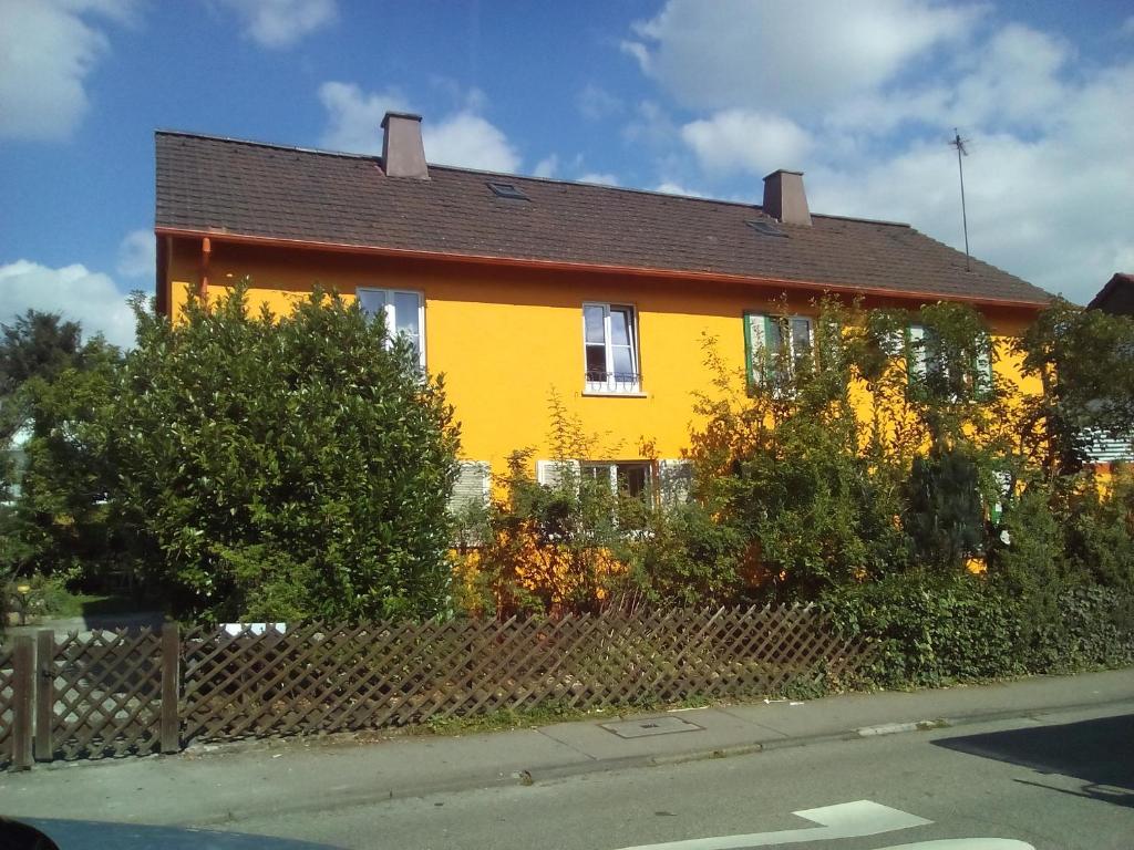 ein gelbes Haus an der Seite einer Straße in der Unterkunft Villa Walter in Leinfelden-Echterdingen