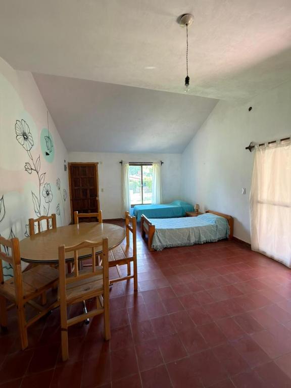 ein Schlafzimmer mit einem Tisch und einem Bett sowie einem Tisch und Stühlen in der Unterkunft El Amanecer in Mina Clavero