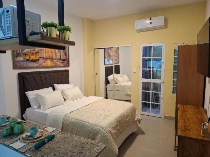 a bedroom with a bed and a room with a window at Studio Lapa in Rio de Janeiro