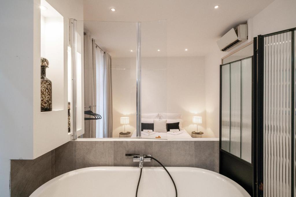 een bad in een badkamer met een bed bij Hyper centre Cannes - 2 pièces avec balcon - 4 couchages in Cannes