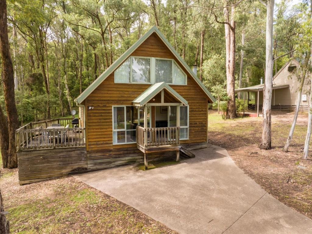 a small house in the woods with a porch at Settle @ Sawmill in Mount Buller