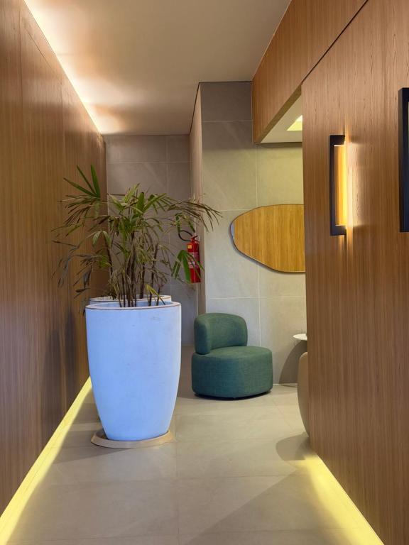 een plant in een grote witte pot in een kamer bij Apartamento moderno no Horto in Ipatinga