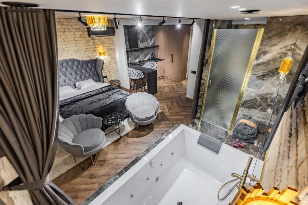 a bedroom with a large bath tub and a bed with a mirror at Basanavičiaus apartament in Vilnius
