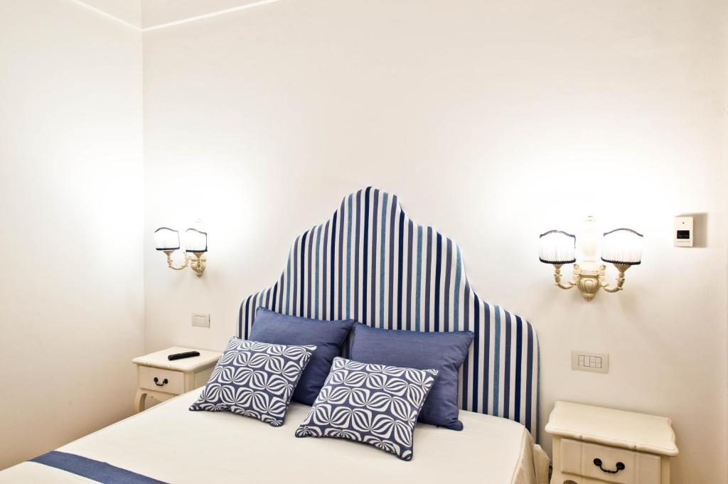 a bedroom with a bed with blue and white pillows at Casa Cinque in Positano