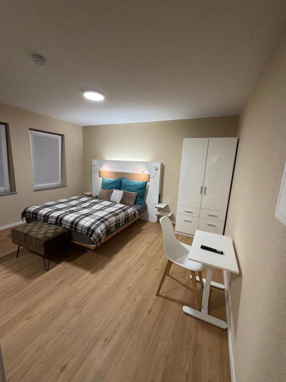 een slaapkamer met een bed, een bureau en een stoel bij Pension Elisa in Bad Friedrichshall