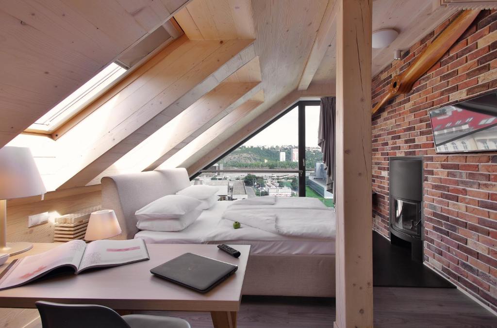 a room with four beds and a desk and a brick wall at Absolutum Wellness Hotel in Prague